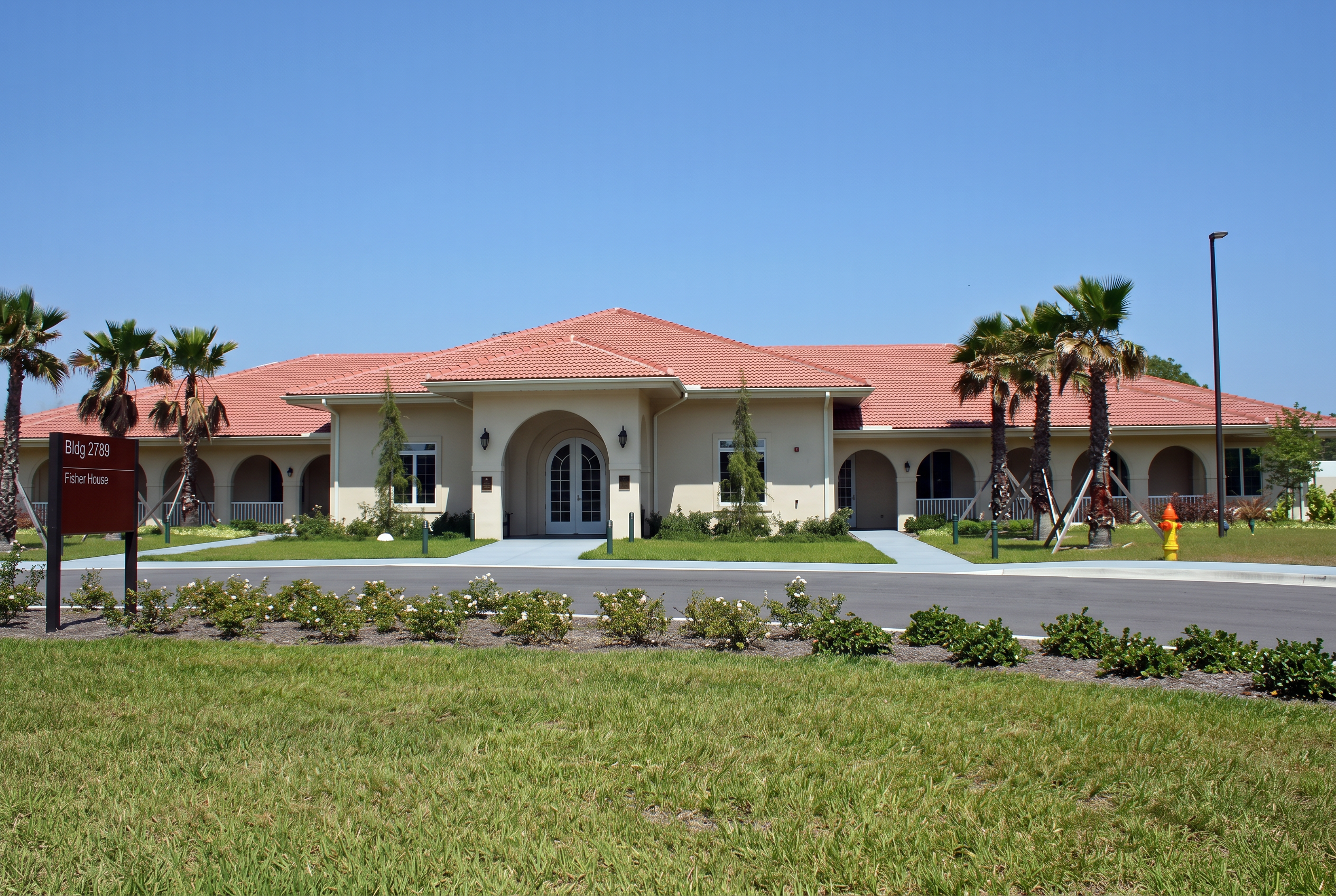Fisher House of the Emerald Coast exterior with red tile roof and palm trees
